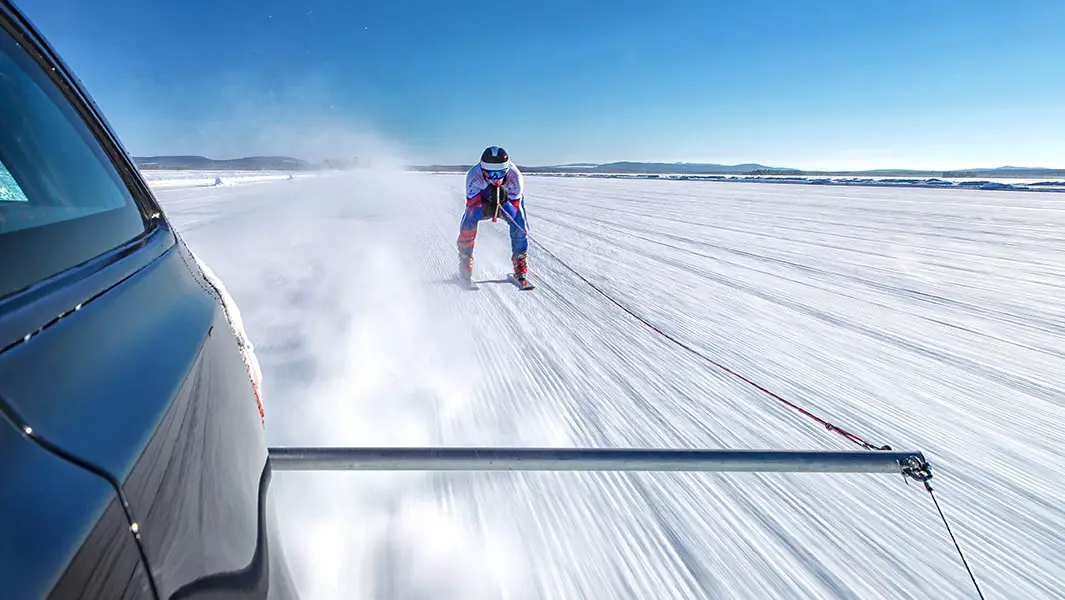 ジャガー・ランドローバーが時速189.07kmでオリンピックスキー選手グラハム・ベルを引っ張る! |ギネス世界記録