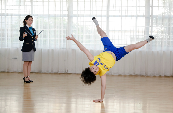 wang doing a one hand handstand while being adjudicated 