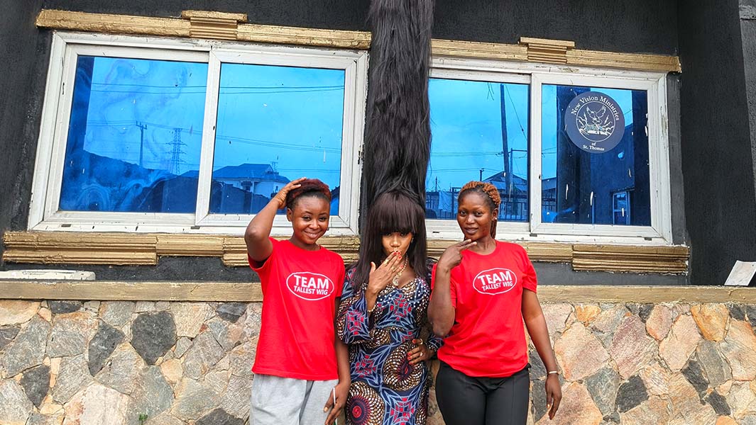 close up of Helen wearing the wig and shot showing it's taller than a building