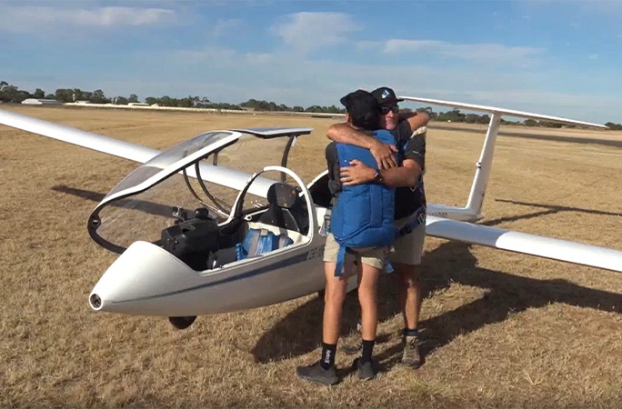 Dave and Max hug on the ground