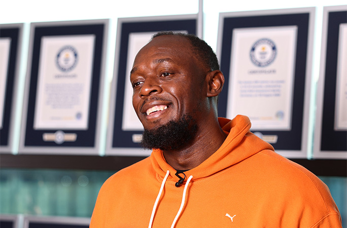 Usain in front of his certificates