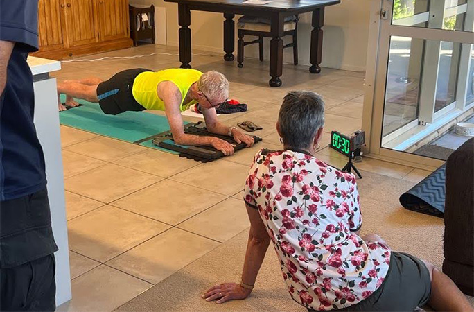 Maynard being kept company while he planks