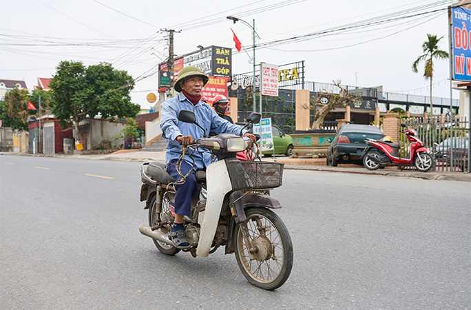 Mr Huyền riding his moped