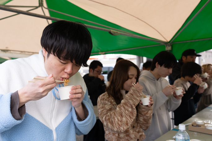 Sideshot of people eating stir-fried noodles