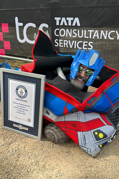 a man dressed as optimus prime lies on his stomach besides a guinness world records certificate