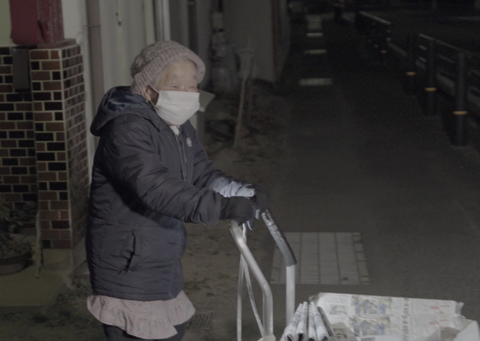 Oldest newspaper delivery person in front of her home