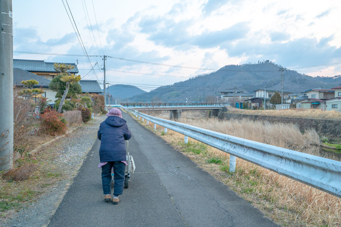 Oldest newspaper delivery person in mountainous background