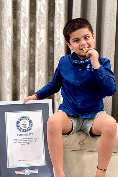 Avyukt with his GWR certificate and biting his medal
