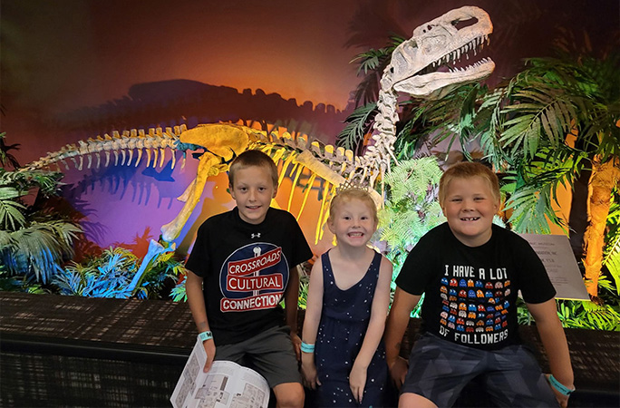 kids posing with dinosaur