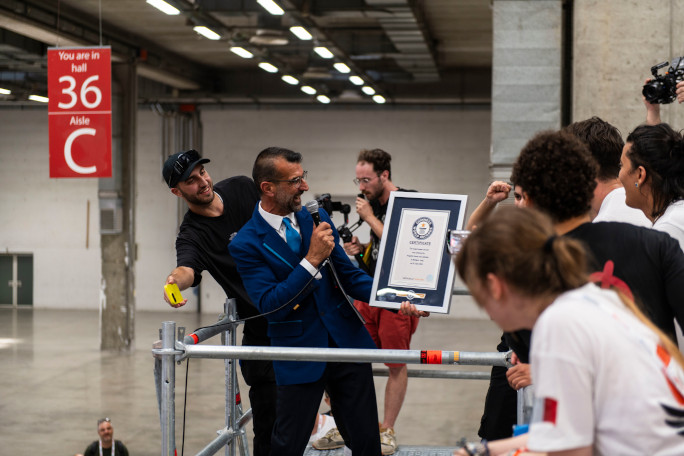 Adjudicator on the scaffolding handing out the certificate