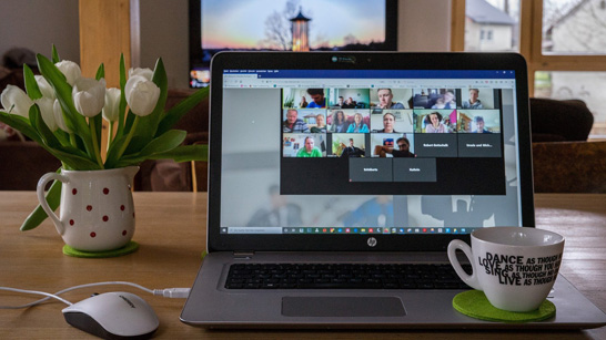 laptop on table with mug and flowerpot
