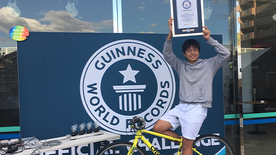 Bicycle Electricity boy holding gwr certificate on electric bike next to GWR challenge poster