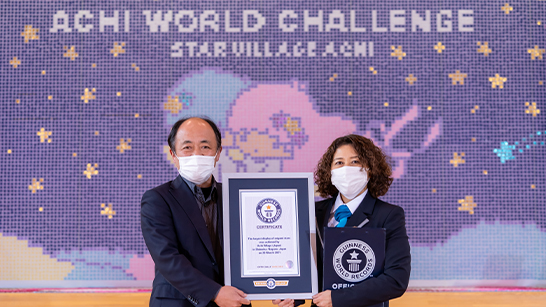 Origami Stars woman holding gwr certificate next to adjudicator