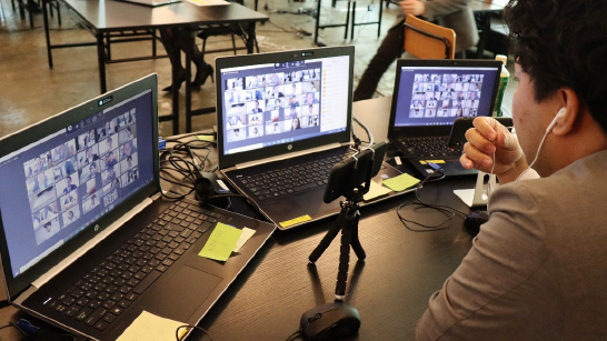 man looking at several laptop screens