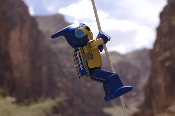 cartoon robot with battery on back climbing up a rope