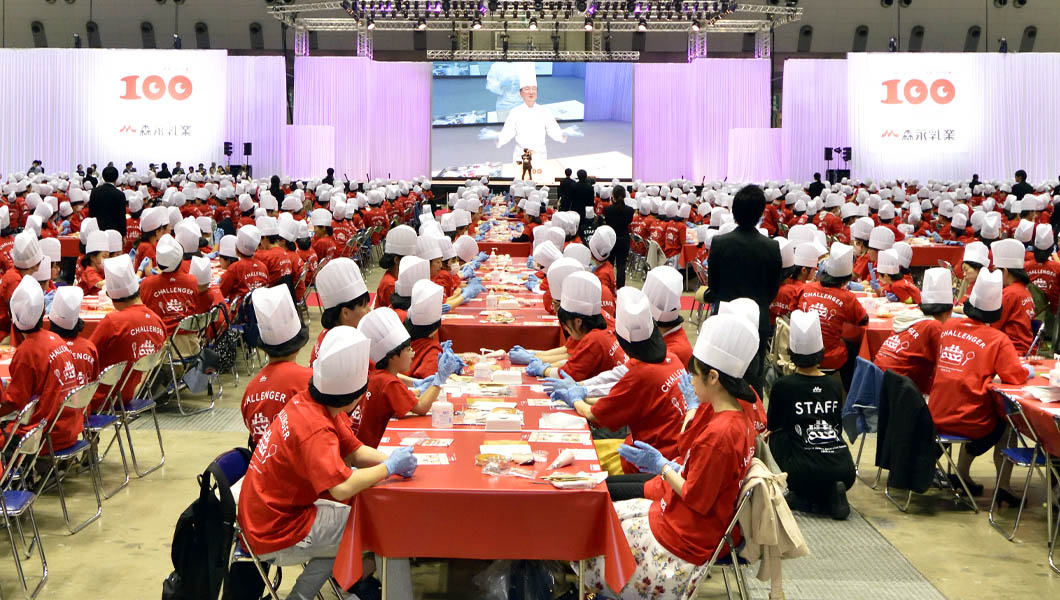 people wearing red jumpers and chef hats sitting down at tables