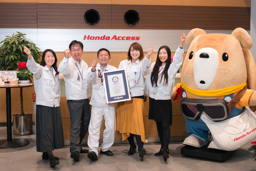 ホンダアクセス公式キャラクターの「はっくるべあ～ くるタム」と共にガッツポーズ