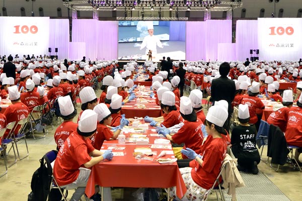 people wearing red jumpers and chef hats sitting down at tables