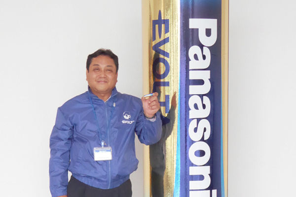 man next to huge panasonic battery